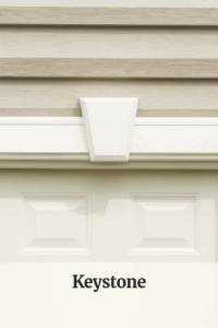 Close-up of a custom-built garage door with decorative trim, showcasing Amish craftsmanship from Lakeside Cabins & Sheds.